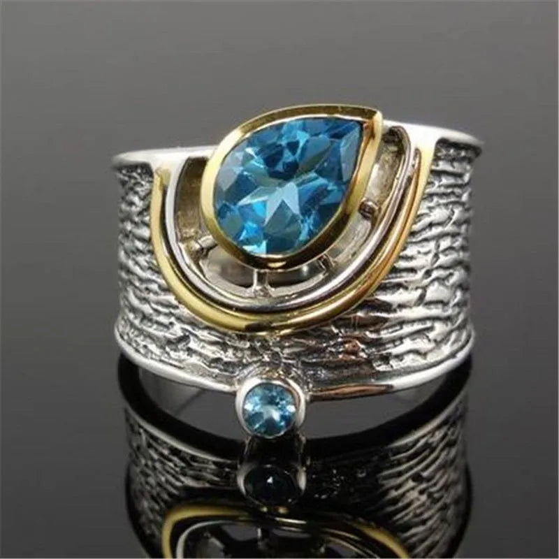 Chinese style blue zircon rhinestone alloy ring in a drop shape on a model's finger.