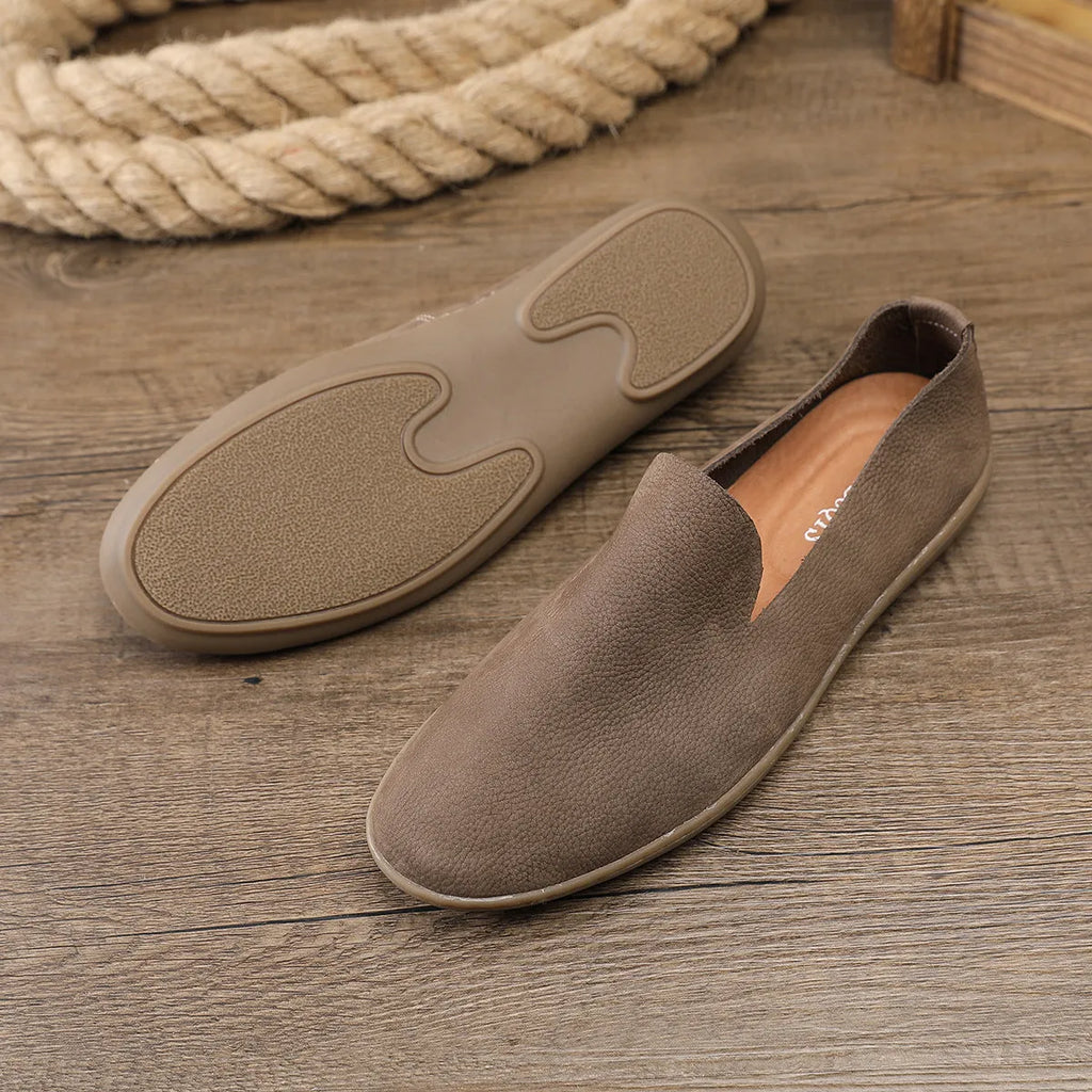 Handmade grey low-top men's casual shoes with a wedge heel and rubber sole on a white background.