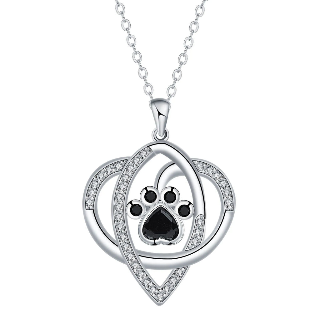 Close-up of a dog's paw print copper pendant necklace on a cross chain.
