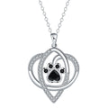Close-up of a dog's paw print copper pendant necklace on a cross chain.