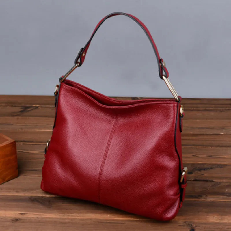 Genuine leather crossbody bag in a vertical square shape with visible sewing lines and a crossbody strap.