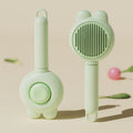 Green pet grooming brush with a self-cleaning button and a stainless steel comb.