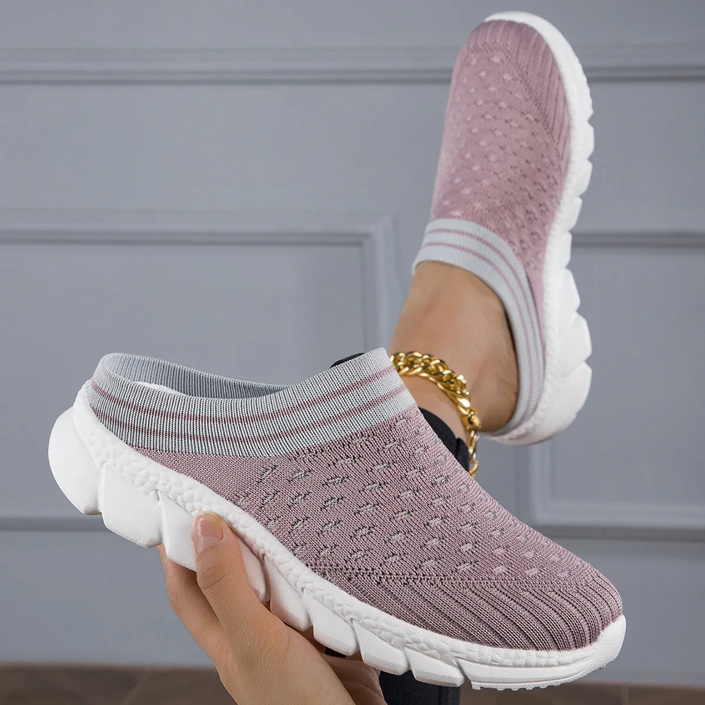 Black women's Flyknit sports slipper with hollowed-out pattern and striped design on a light background.