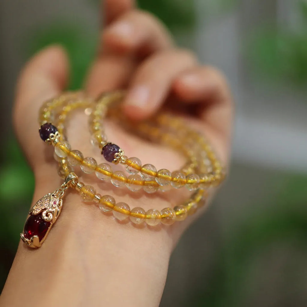 Handmade gold rutilated quartz bracelet with Chinese style design and three-circle pattern.