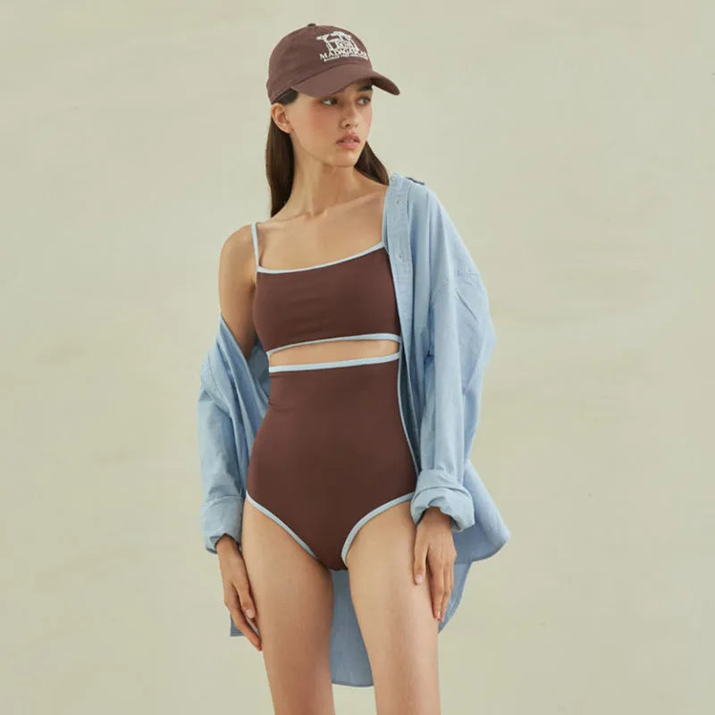 Brown triangle one-piece swimsuit for women on a hanger, showing front design.