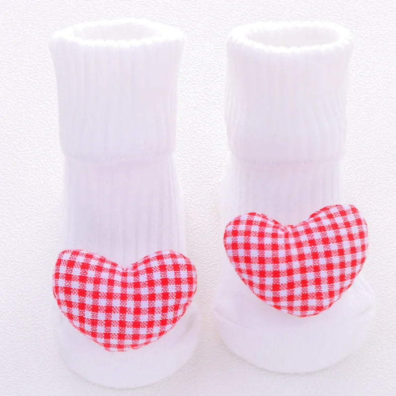 Cotton baby floor socks with non-slip soles in a pink bow print design.