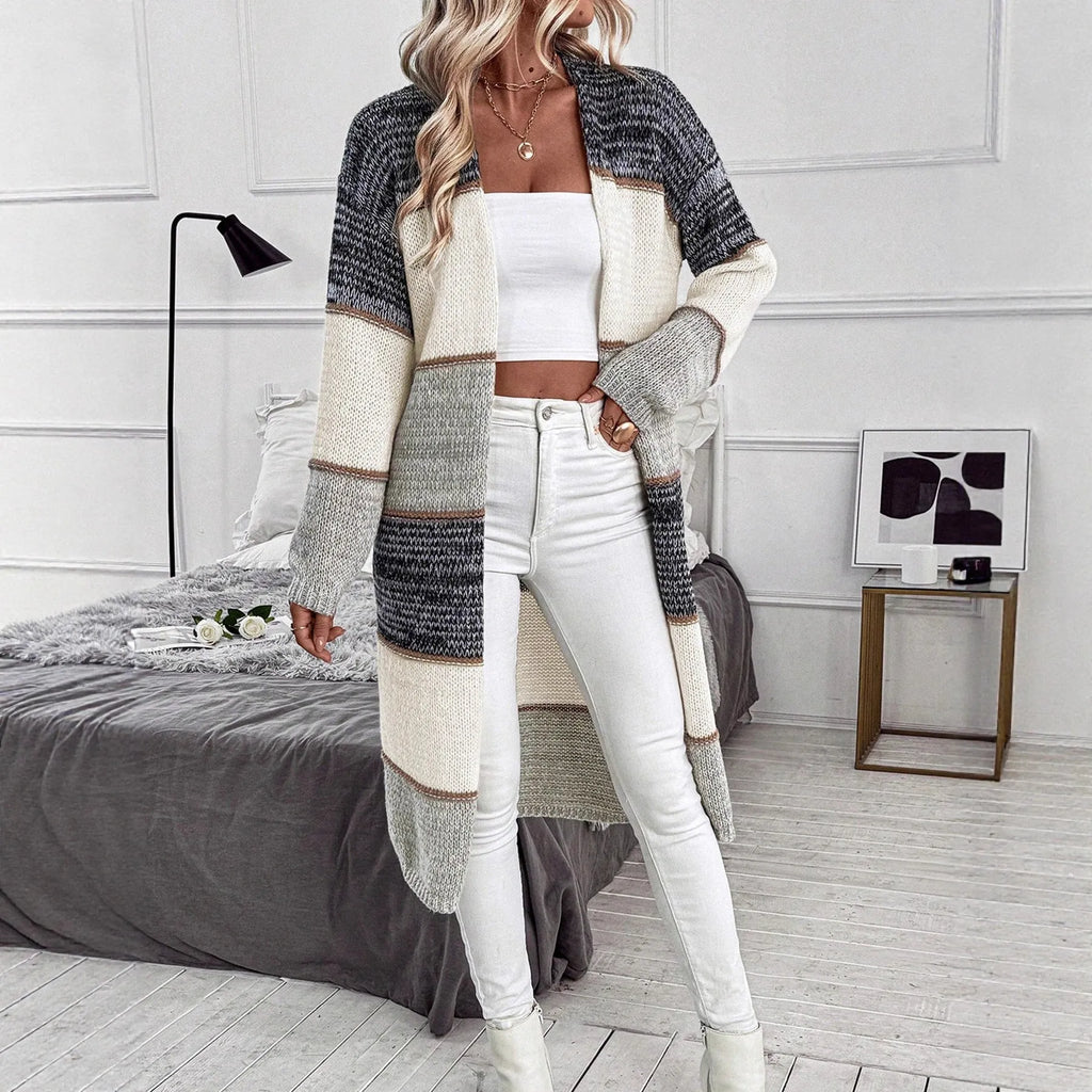 Grey women's loose-fit knitted long cardigan with long sleeves on a hanger.