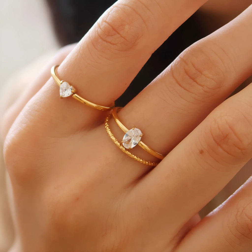 Golden heart-shaped stainless steel ring with electroplated finish shown in sizes 6, 7, and 8