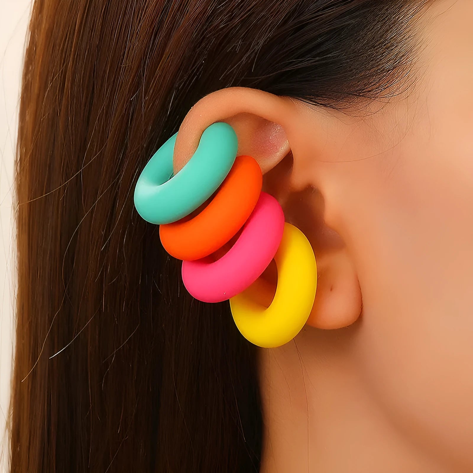 A pair of matte coarse finish round C-shaped clip-on earrings for women, shown in a candy colour.