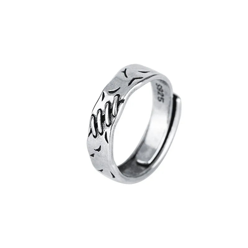 Black geometric copper ring with an adjustable opening on a white background.