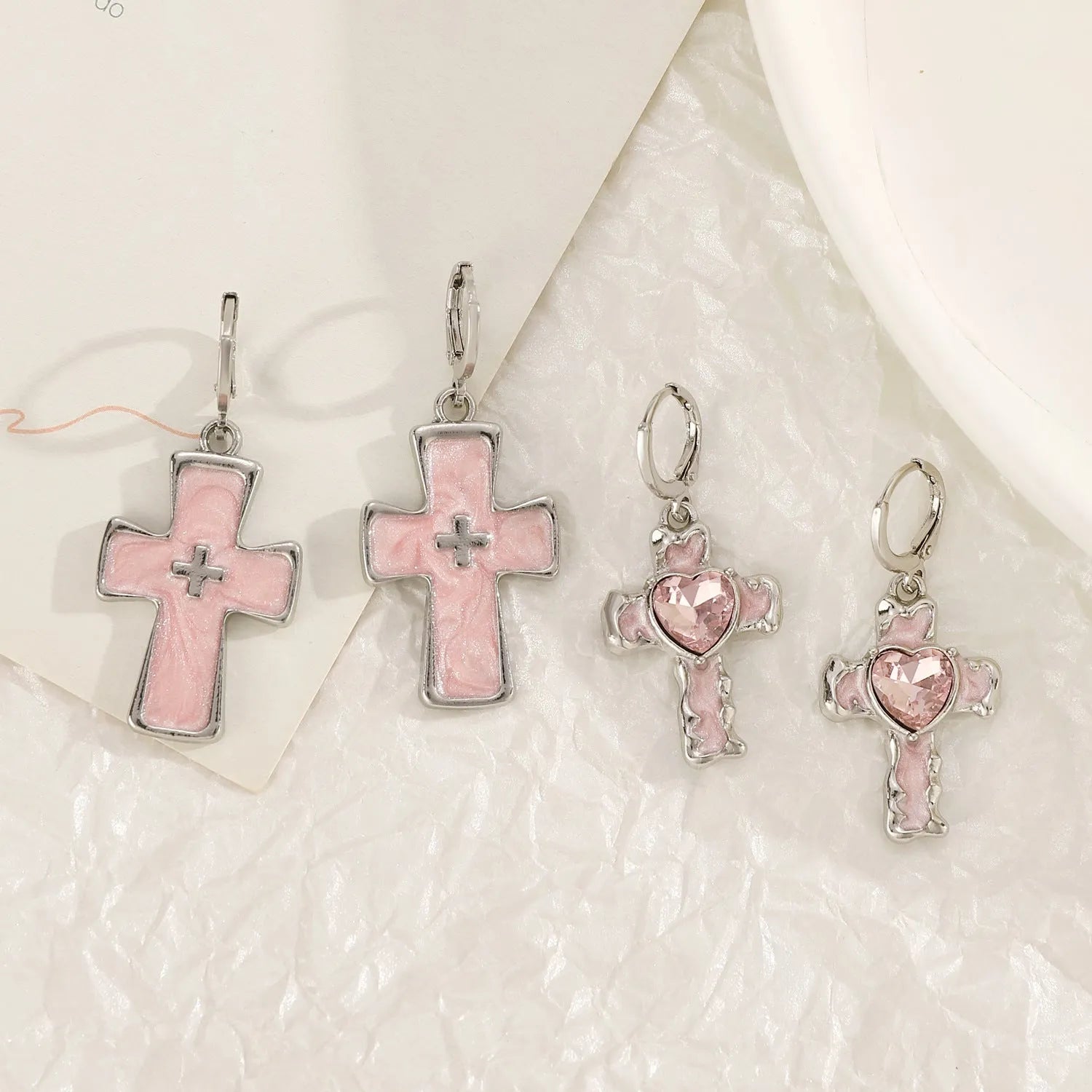 Women's alloy earrings showing cross, heart, and cat designs in white, black, and antique silver finishes.