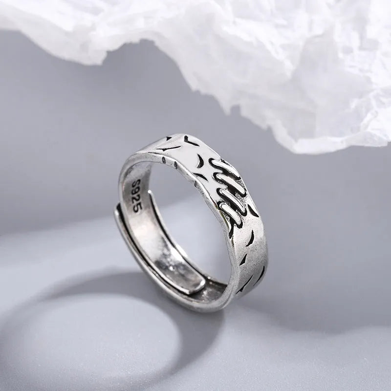 Black geometric copper ring with an adjustable opening on a white background.