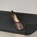 Women's black chunky heel pumps with a round toe and distinctive split toe horseshoe design detail.