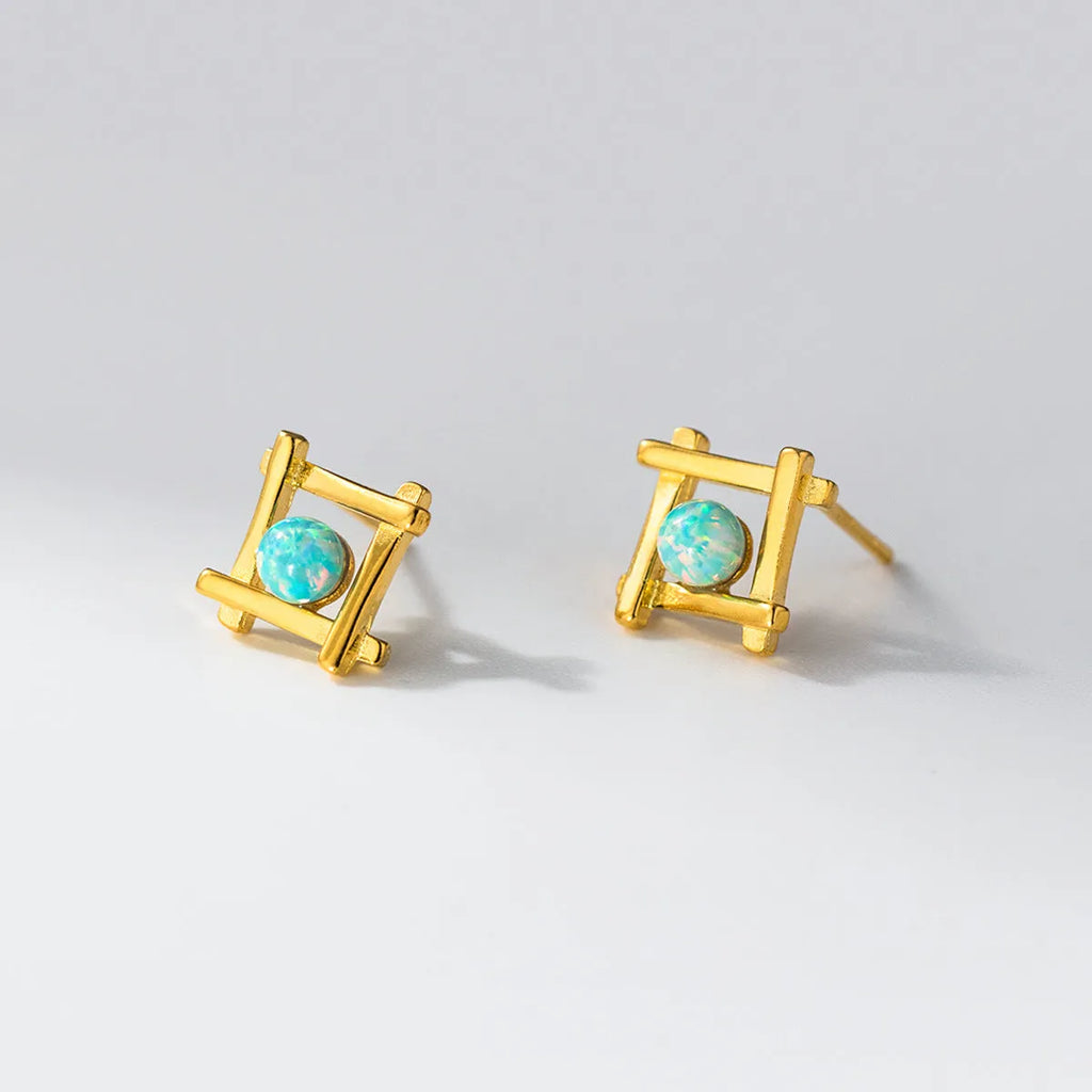 Geometric cross-shaped silver stud earrings with angular design, available in gold or silver finish.