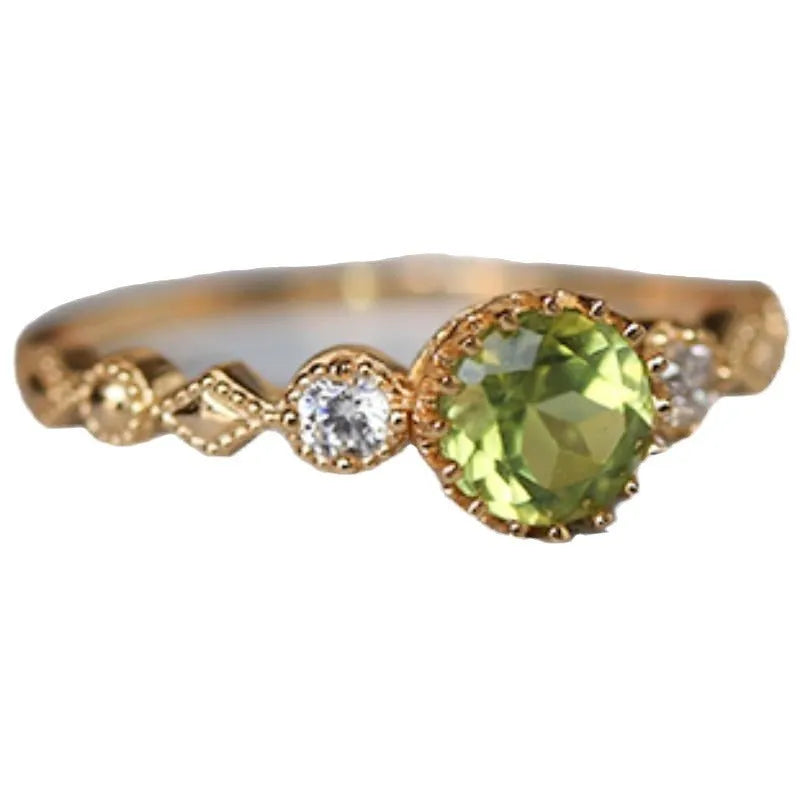 Japanese style geometric copper ring with imitation peridot stone on a model's finger.