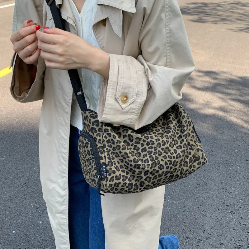 Leopard print cross-body messenger bag with shoulder strap and stitching details
