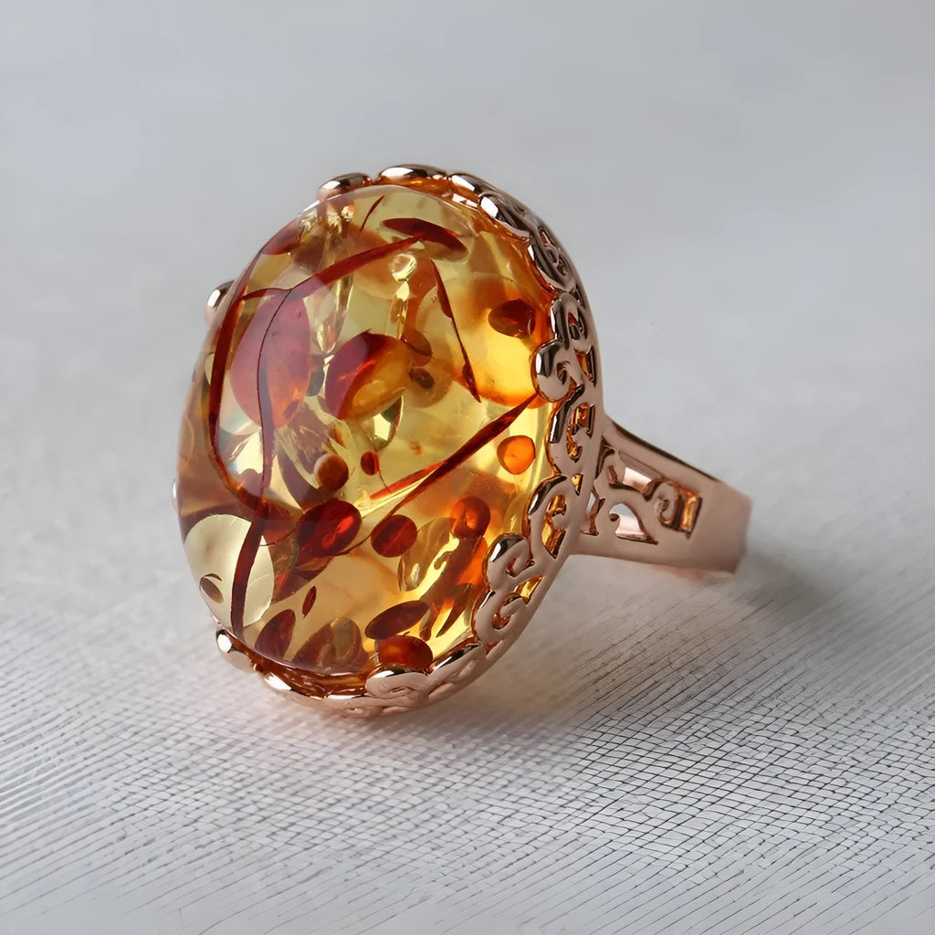Close-up of a hand-carved beeswax amber ring in New Amber Type A colour on an alloy band, showing ethnic retro design.