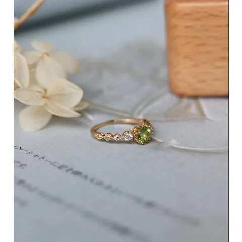 Japanese style geometric copper ring with imitation peridot stone on a model's finger.