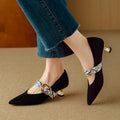 Women's black pointed toe stiletto heels with a buckle fastening on the side