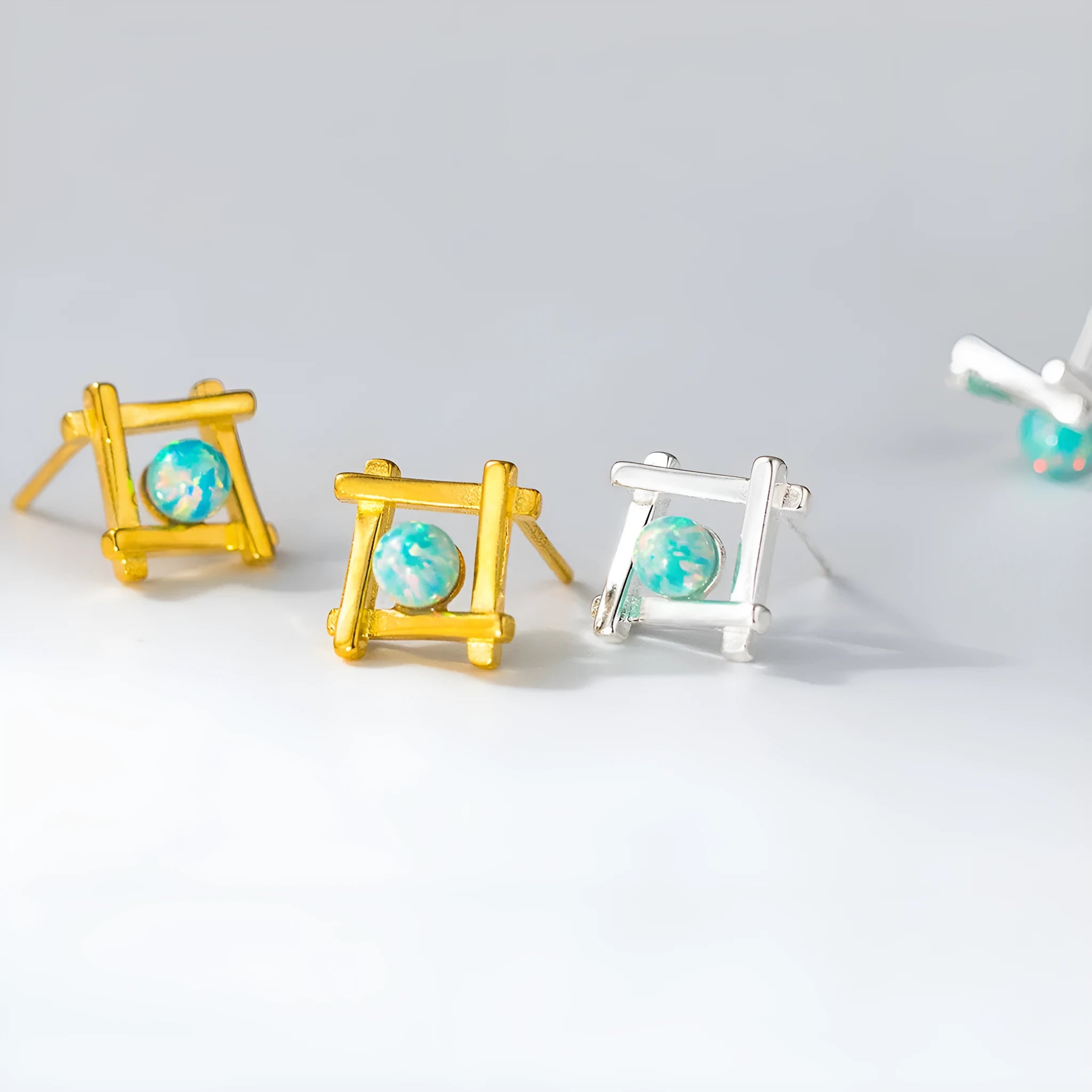 Geometric cross-shaped silver stud earrings with angular design, available in gold or silver finish.