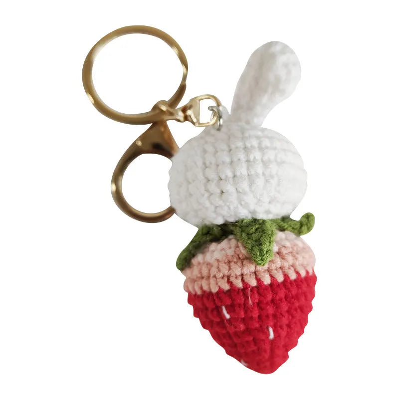 White hand-woven rabbit strawberry wire pendant with key on a white background