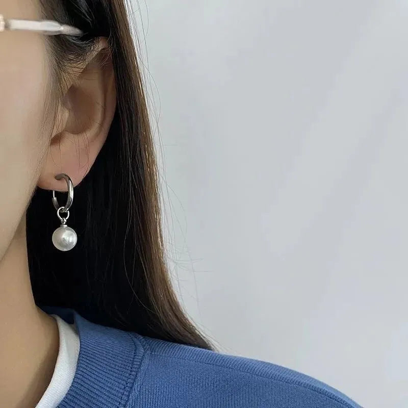 A pair of women's geometric alloy earrings with round pearl details and titanium steel posts.