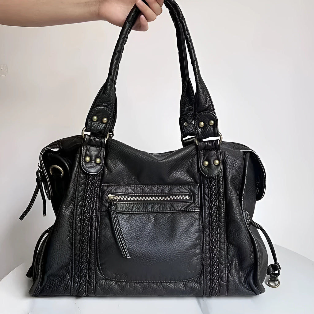 Women's retro motorcycle style messenger bag in bright black with golden edge, showing internal zipper compartments and single shoulder strap