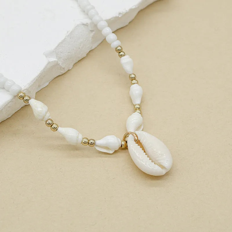 White conch shell necklace with mother pearl pendant on a regular electroplated chain.