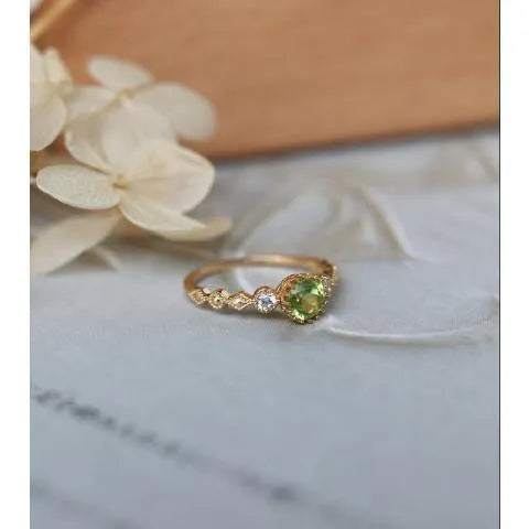 Japanese style geometric copper ring with imitation peridot stone on a model's finger.