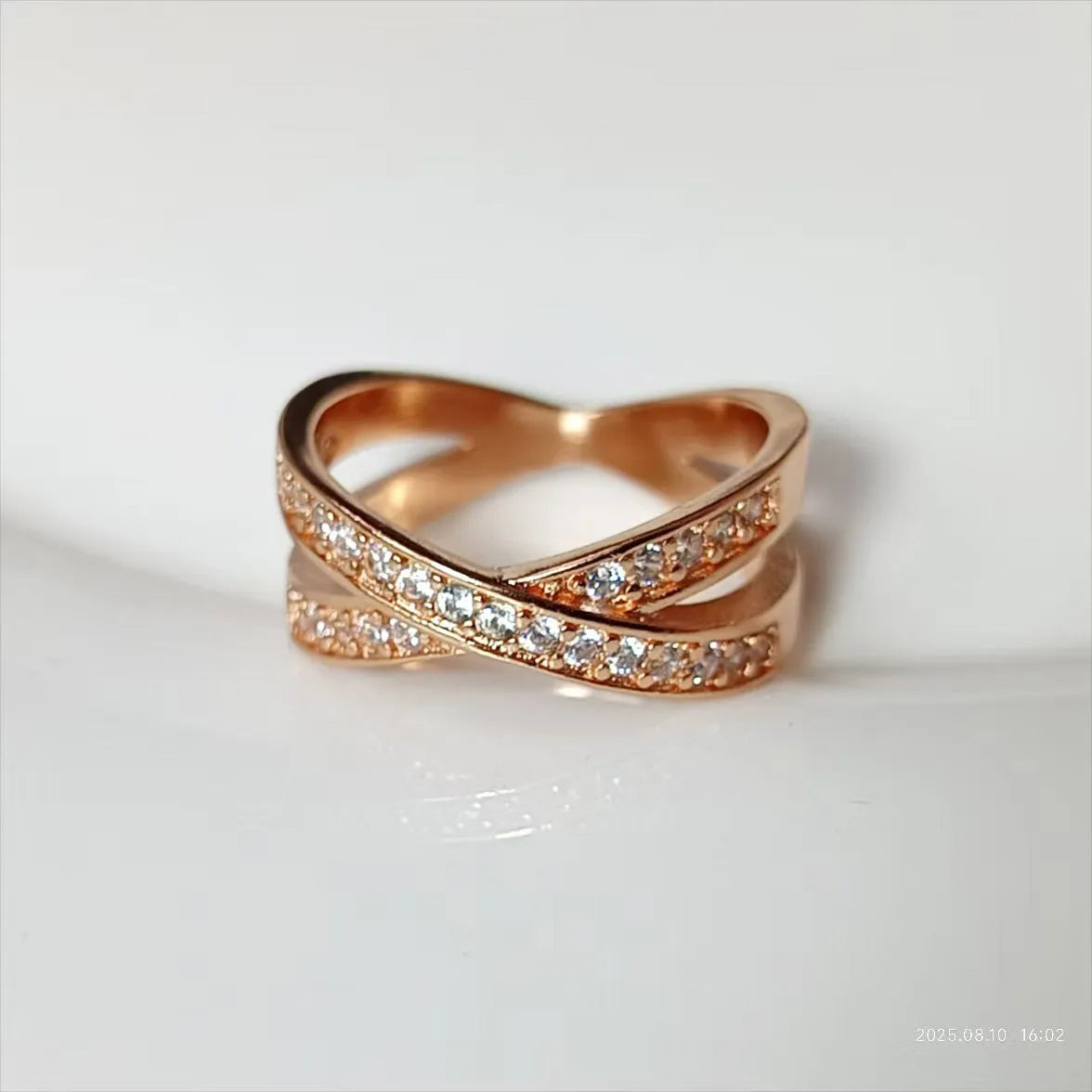 Close-up of a silver cross ring with micro-inlaid zircon details on a simple band.