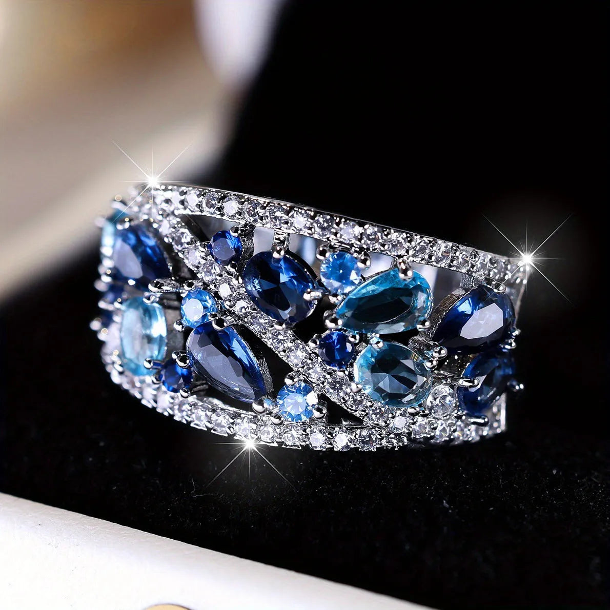 Women's round hollow fashion ring in gold or platinum with a white diamond or navy blue sapphire stone.