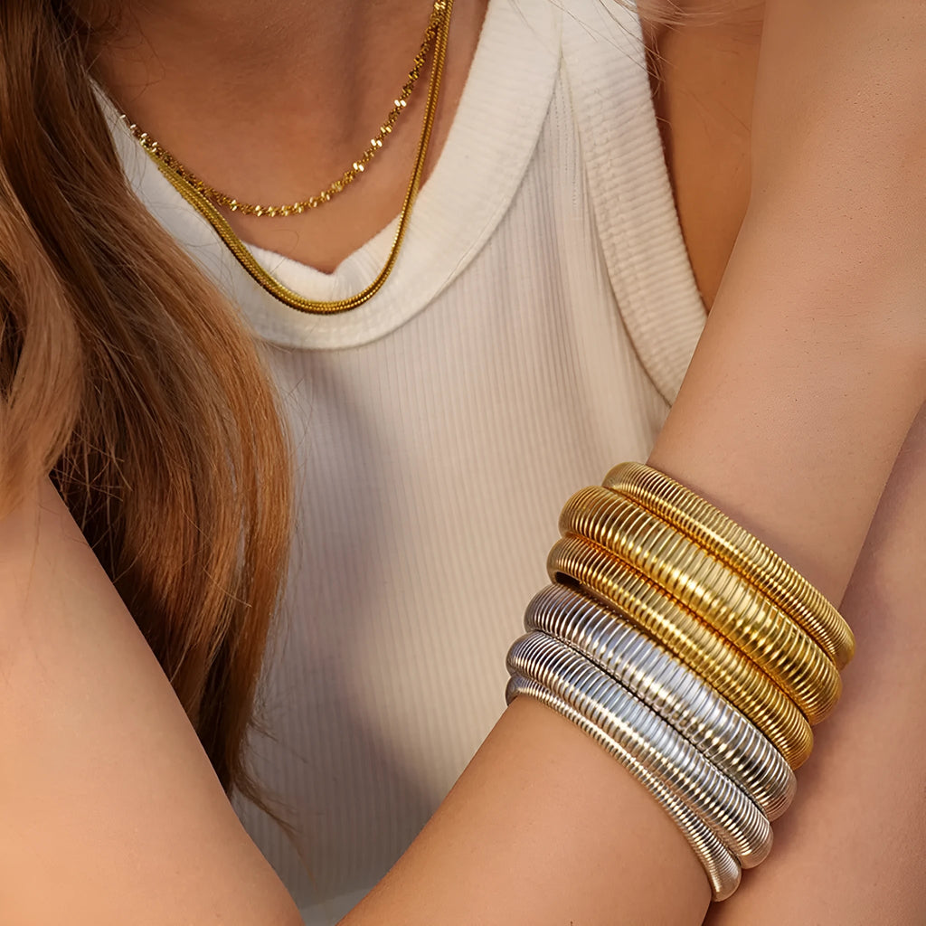 Women's titanium steel elastic bracelet with vertical stripe pattern and ring elements in gold finish