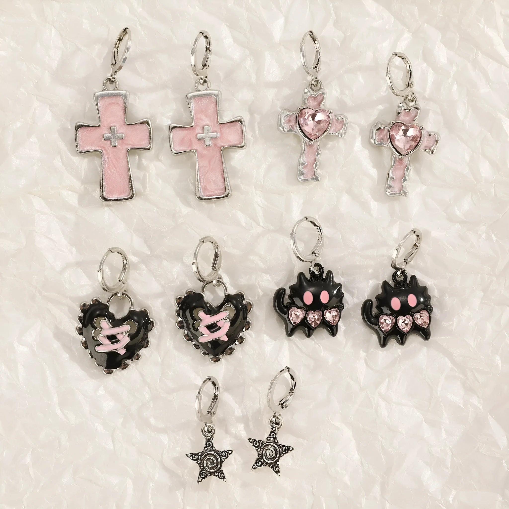 Women's alloy earrings showing cross, heart, and cat designs in white, black, and antique silver finishes.