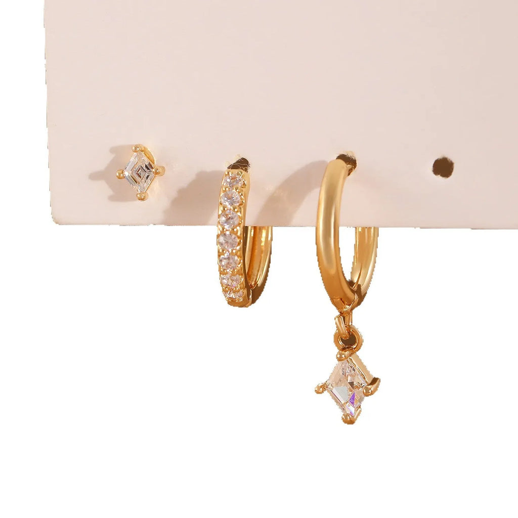 Ladies three-piece earring set with geometric zircon designs in gold and white colours showing pendant, stud, and clip styles