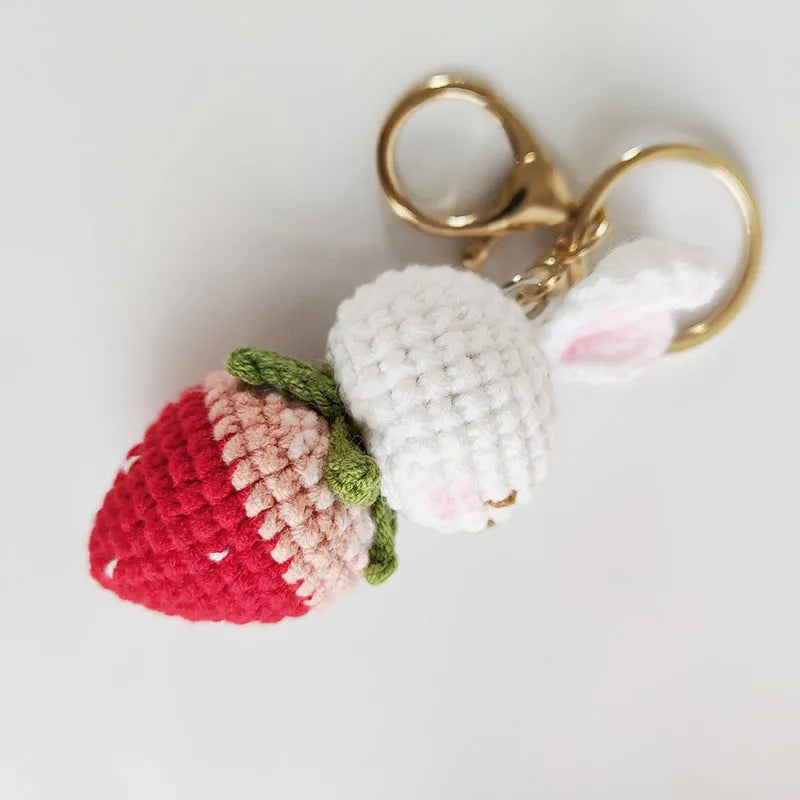 White hand-woven rabbit strawberry wire pendant with key on a white background