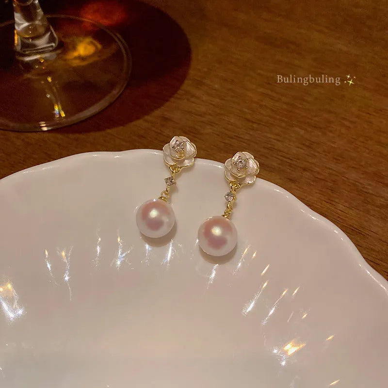 A pair of camellia flower-shaped stud earrings for women in alloy.