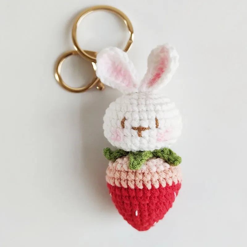 White hand-woven rabbit strawberry wire pendant with key on a white background