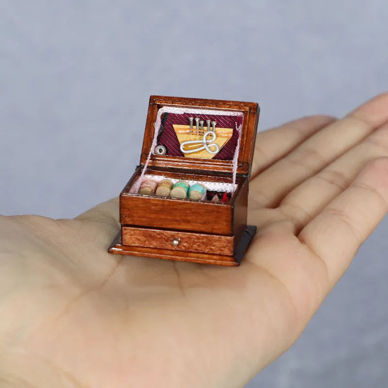 Small vintage sewing machine miniature ornament in a birch wood box with accessories.