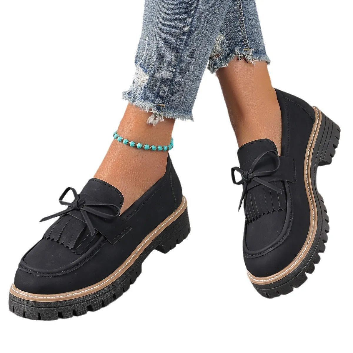 Women's plus size black loafers with tassel detail and a chunky flat rubber sole.