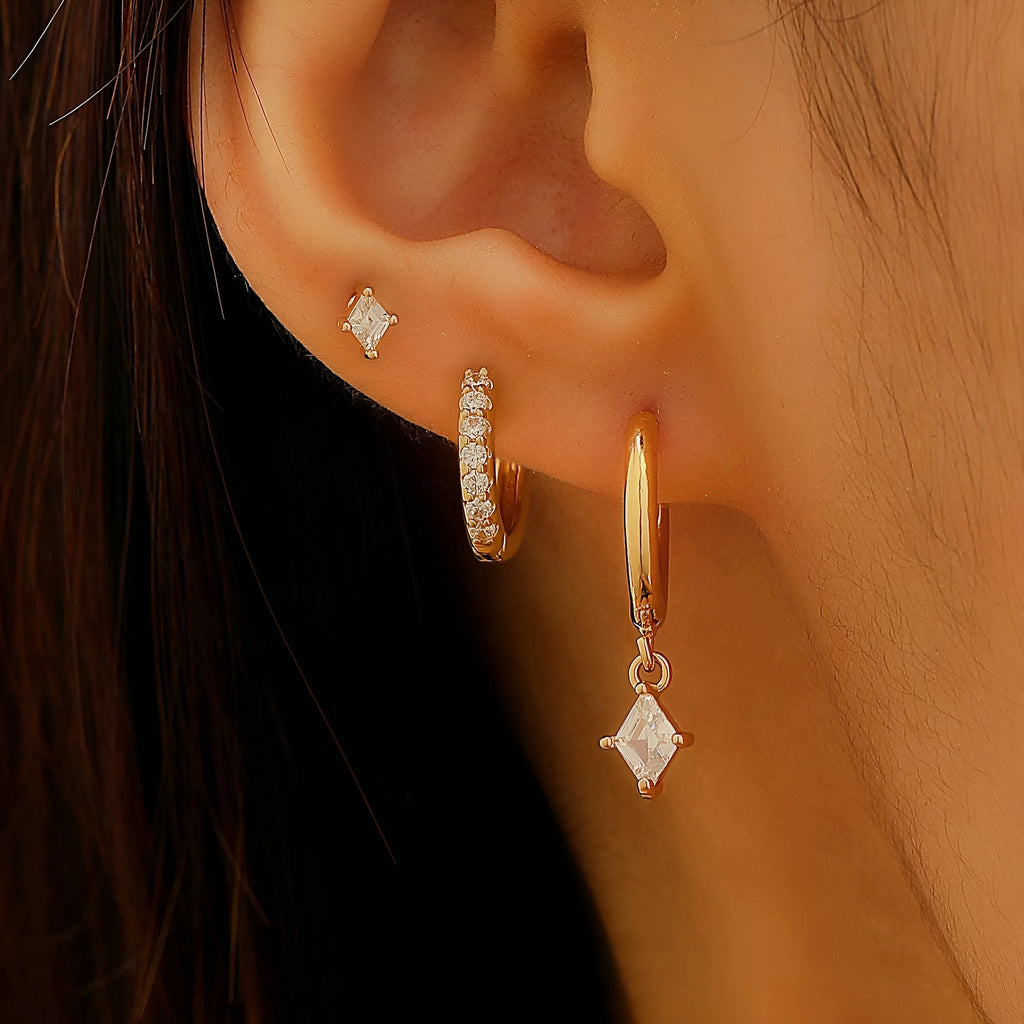 Ladies three-piece earring set with geometric zircon designs in gold and white colours showing pendant, stud, and clip styles