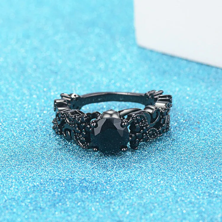 Unisex copper punk electroplated black gold ring with inlaid black zircon stone and olive branch motif on black background