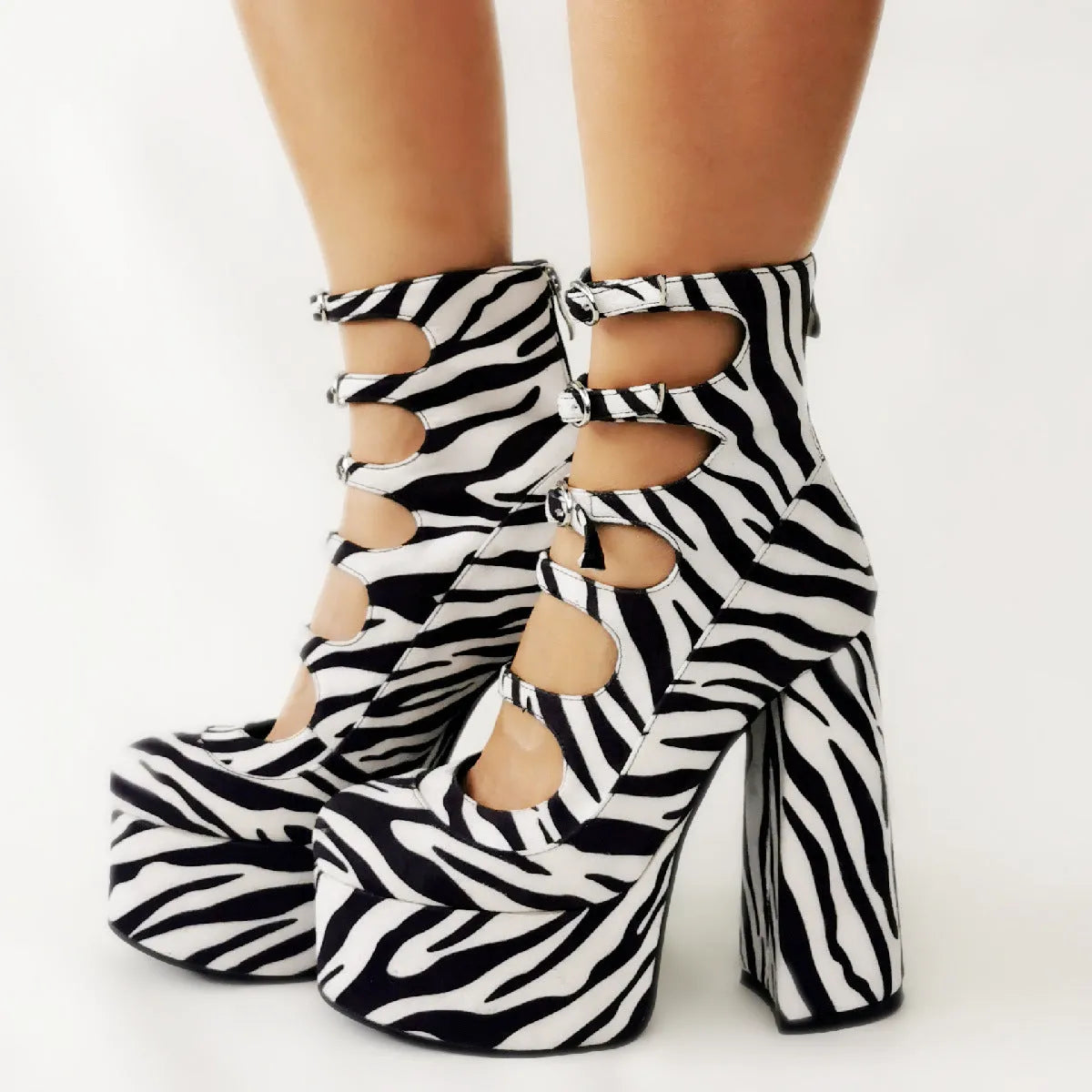 Women's black patent leather platform high heels with a thick heel and silver buckle fastening.