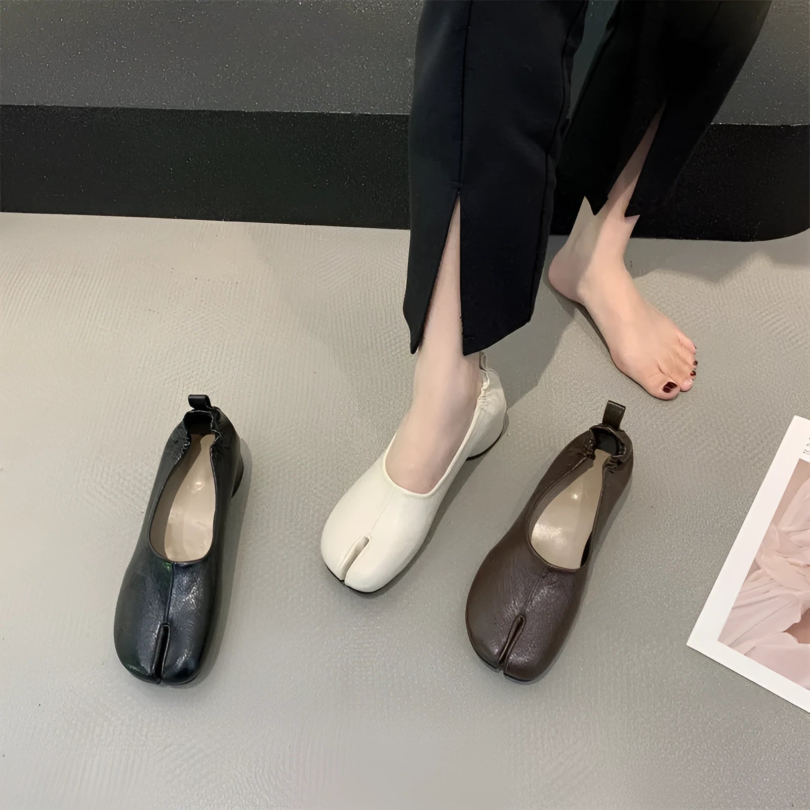 Women's black chunky heel pumps with a round toe and distinctive split toe horseshoe design detail.