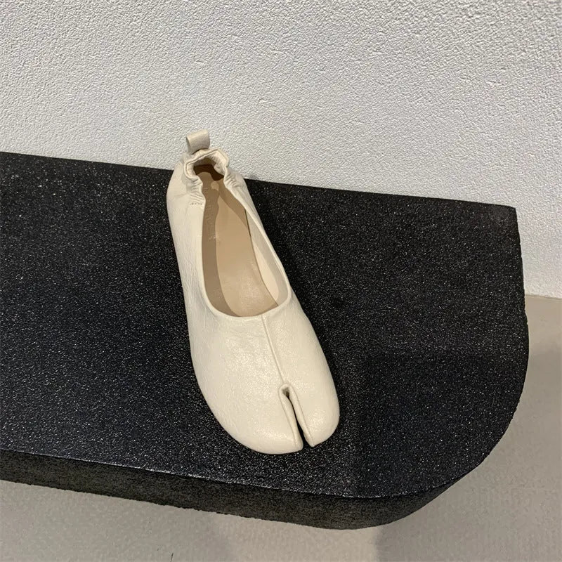 Women's black chunky heel pumps with a round toe and distinctive split toe horseshoe design detail.