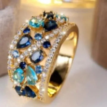 Women's round hollow fashion ring in gold or platinum with a white diamond or navy blue sapphire stone.
