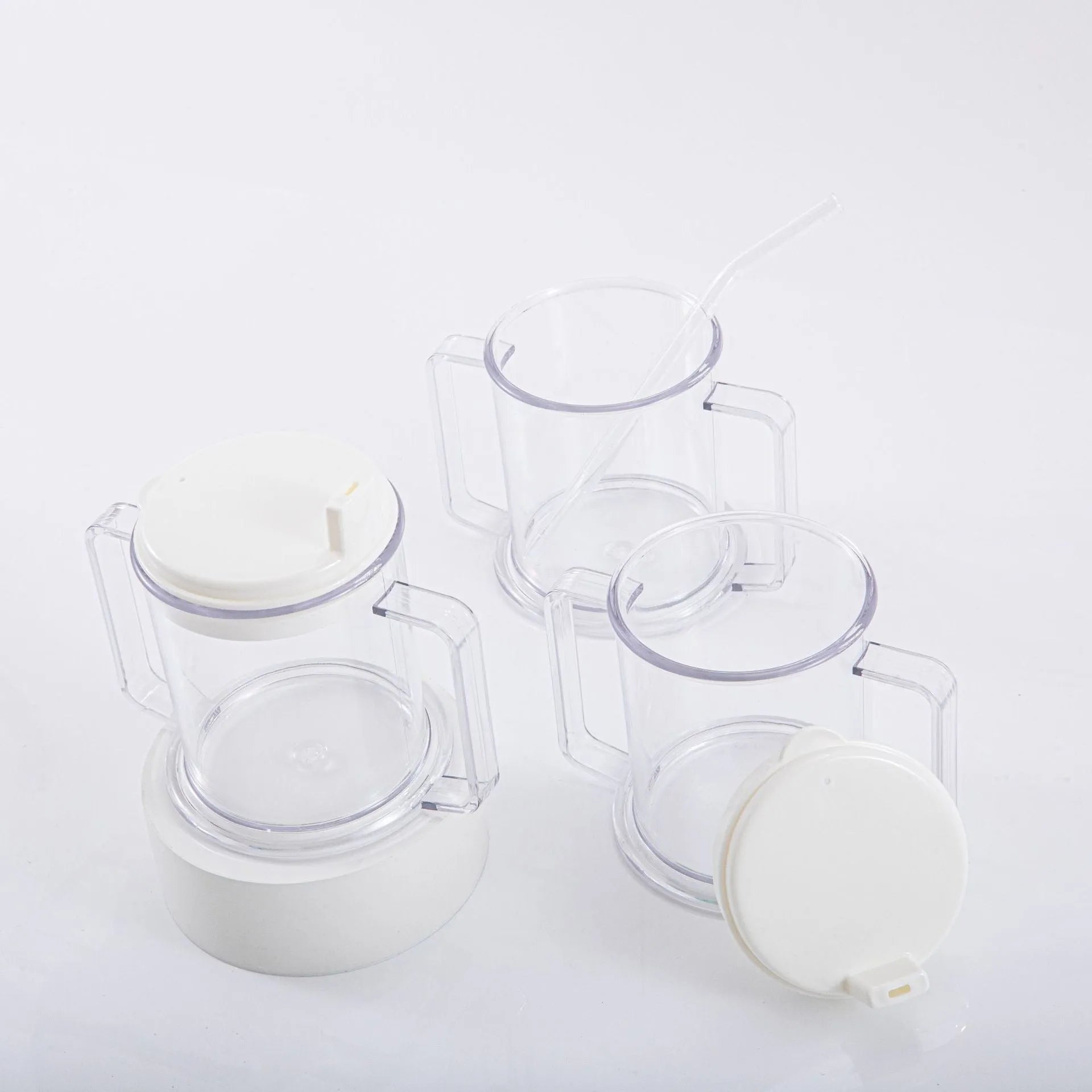Transparent plastic drinking cup with a black spill-proof lid on a white background