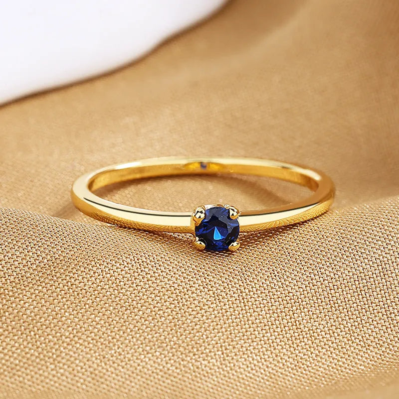 Twin style women's copper ring with a single round diamond, shown in blue, green, red, and white colour options.