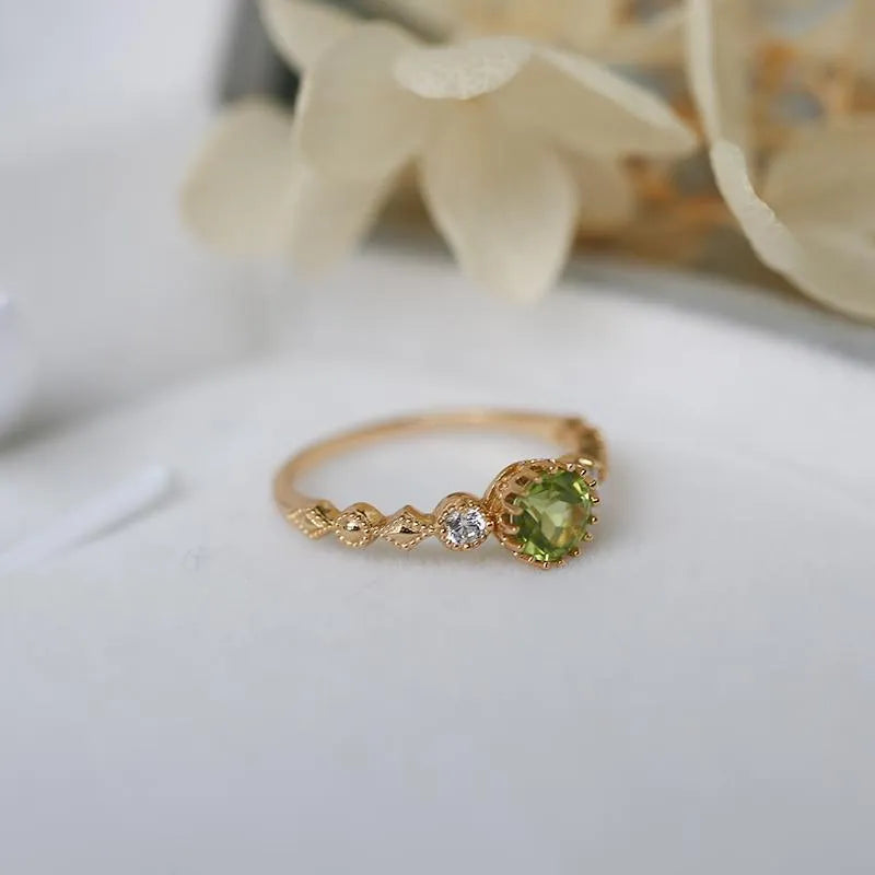 Japanese style geometric copper ring with imitation peridot stone on a model's finger.