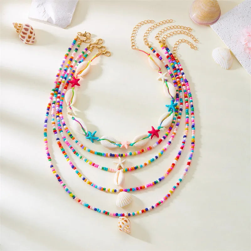 Five women's necklaces with shell and conch bead pendants on adjustable electroplated alloy chains
