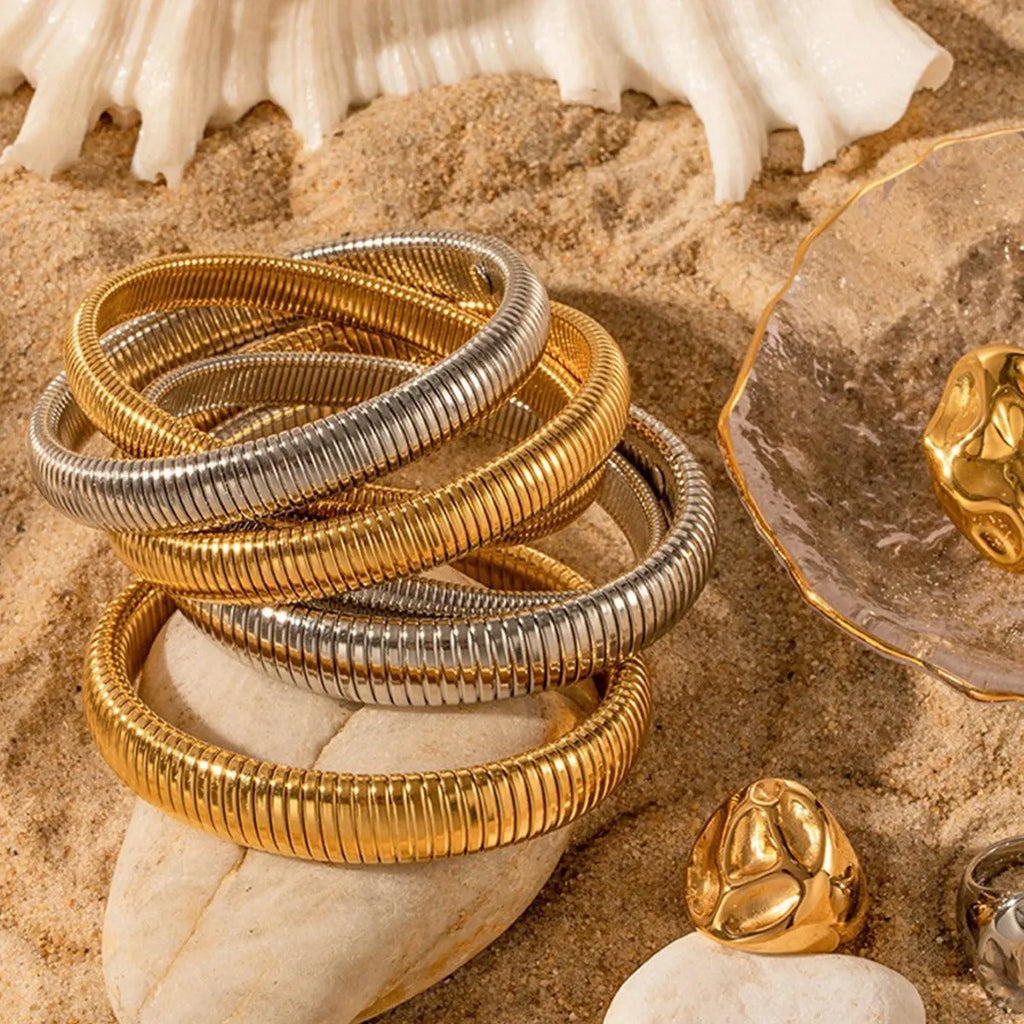 Women's titanium steel elastic bracelet with vertical stripe pattern and ring elements in gold finish